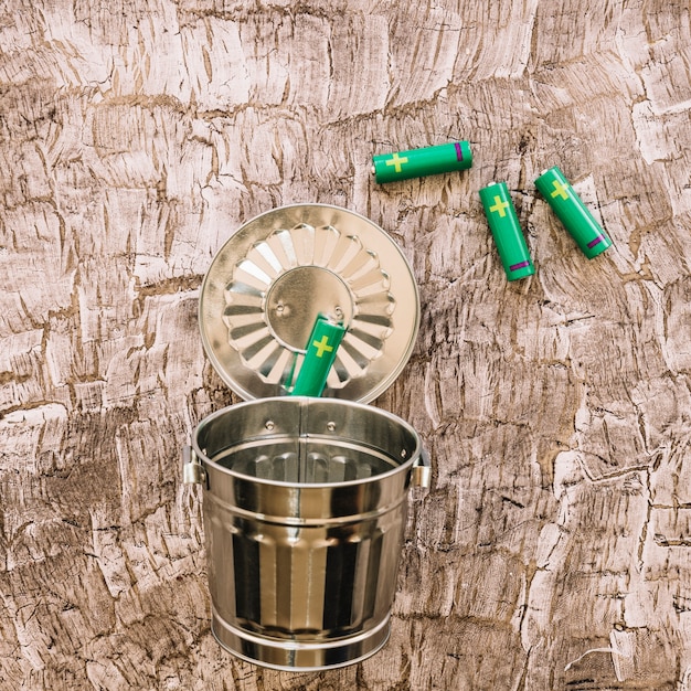 A close-up shot of a recycling bin overflowing with neatly sorted materials in a modern office setting, emphasizing the importance of waste reduction and recycling in corporate sustainability efforts. A hand is shown placing a recyclable item into the bin.
