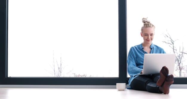 A person using a laptop to compare health insurance plans online. The background is a bright and modern office.
