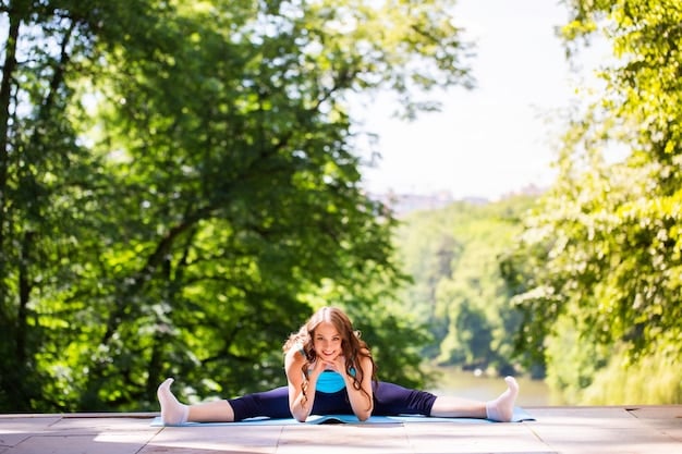 A person doing stretching exercises with a serene outdoor background, emphasizing the importance of flexibility and balance in a well-rounded fitness routine and the calming effect of exercising in nature.