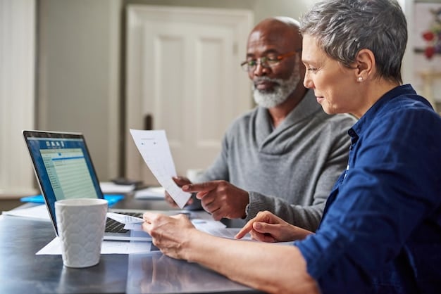 A diverse group of people sitting at a table, reviewing health insurance policy documents and using a laptop to compare different plan options.