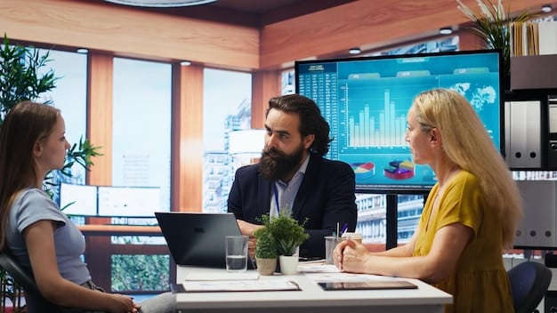 A group of economists or financial analysts in a meeting room, looking at charts and discussing economic data on a large screen. Emphasize data visualization and collaborative analysis.