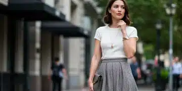 Woman blending vintage A-line skirt with modern top in city street.